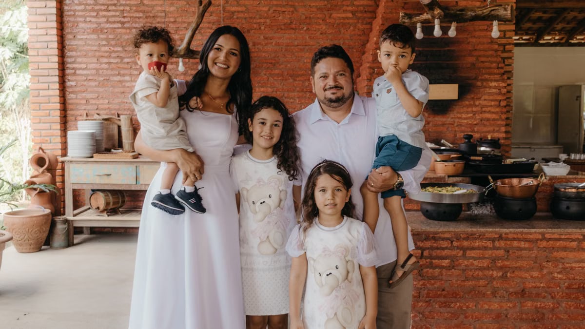 A joyful family portrait in a cozy rustic kitchen setting with a warm atmosphere.
